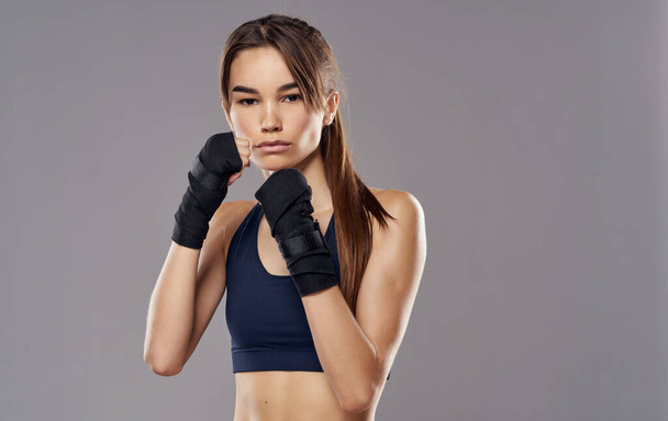 Frau Boxer in Handschuhen auf grauem Hintergrund abgeschnitten Ansicht der brünetten Modell - Foto, Bild