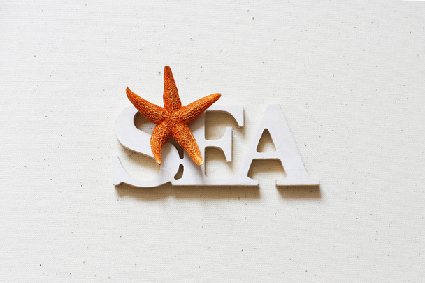 White wooden word sea on textile background with starfish - Φωτογραφία, εικόνα
