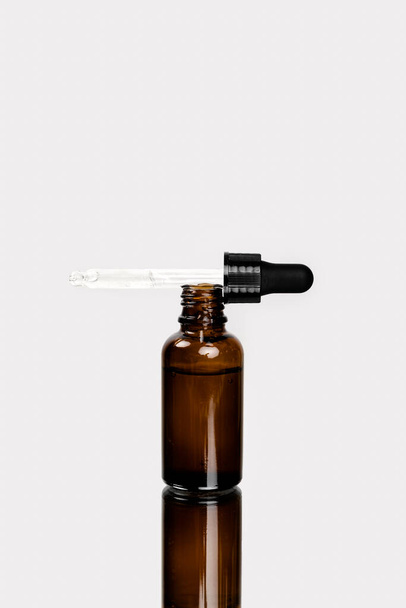Concepto de cuidado facial y corporal, cosméticos naturales saludables en botellas reutilizables de vidrio oscuro. Ácido hialurónico con pipeta - Foto, imagen