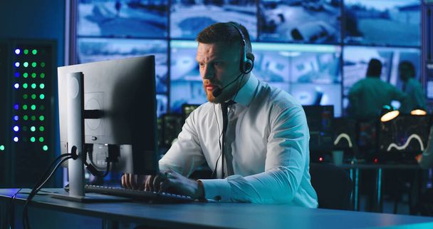 Operador masculino usando computador no centro de vigilância - Foto, Imagem