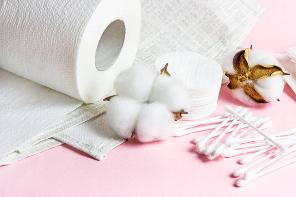 Weiße weiche Baumwollkissen und -stäbe für Hygiene und Gesundheit auf hellrosa Hintergrund. - Foto, Bild