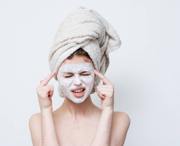 woman with a white mask against black dots on her face and a towel on her head - Foto, Imagem