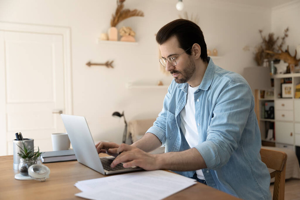 Millennial man work distant on laptop from home - Fotoğraf, Görsel