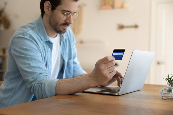 Millennial man shopping online on computer with card - Zdjęcie, obraz