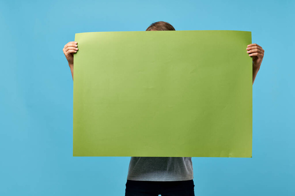 muž drží zelený banner marketing kopírovat prostor modrá reklama pozadí - Fotografie, Obrázek