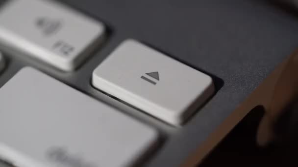 Vista macro de dedo humano presionando una tecla de expulsión en el teclado de la computadora - Metraje, vídeo