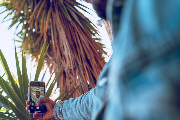 Schwarzer Junge macht Handy-Selfie an Ziegelmauer - Foto, Bild