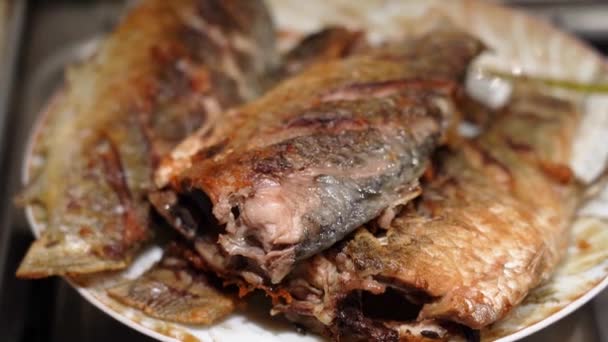 Ruokahalua paistettu crucian kala makaa lautasella, kamera pyöreä liike - Materiaali, video