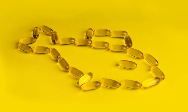 Sarı arkaplanda omega 3 jel kapsülleri - Fotoğraf, Görsel