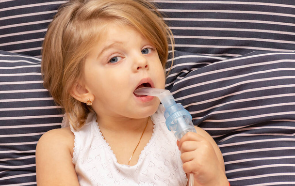 喘息やアレルギーを持つ病気のブロンドの女の子はネブライザーを通して吸入され - 写真・画像