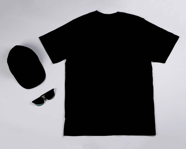 Zwykła czarna makieta koszulki odizolowana na białym tle. Nadaje się do Twojej powierzchni reklamowej marki. Miejsce do wklejenia logo. Czarna koszulka Mock Up Wallpaper. Zwykła koszulka. Widok z góry - Zdjęcie, obraz