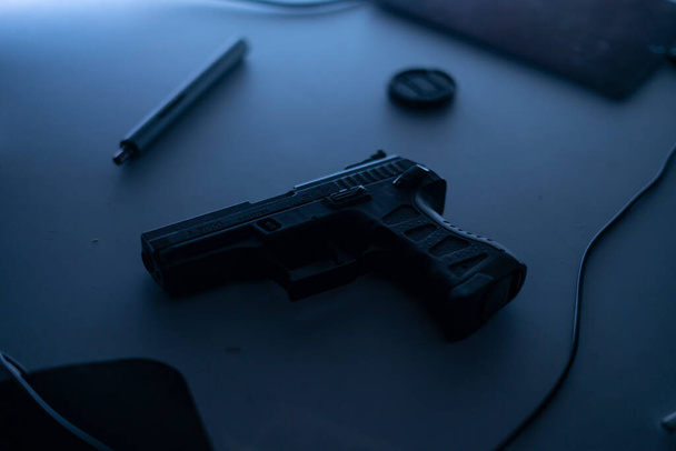 the black 9mm pistol gun on the table in dark room, plan to make a crime or terror - Photo, Image