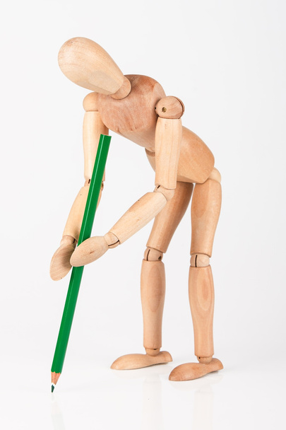 Small wood mannequin stand writing with colour pencil isolated o - Foto, immagini