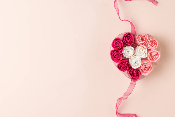 Τριχρωμία σε σχήμα καρδιάς μπουμπούκια τριαντάφυλλου σε παστέλ φόντο. Η έννοια της αγάπης. - Φωτογραφία, εικόνα