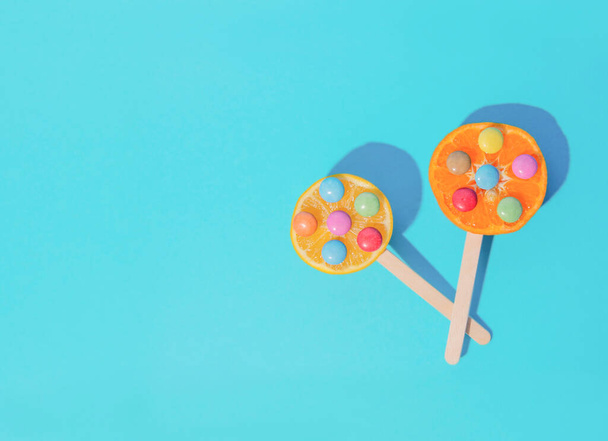 Tropische zomer scene met fruit lolly 's met een blauwe achtergrond. Minimale esthetiek. Het begrip verfrissing. - Foto, afbeelding