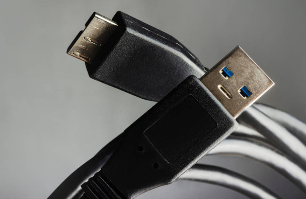 Detailní fotografie černých kabelů USB na šedém pozadí. - Fotografie, Obrázek