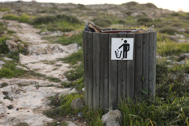 poubelle ou poubelle en bois avec pour bouteille, canette de bière et déchets organiques visible montrant la pollution dans les zones côtières près de la mer. - Photo, image