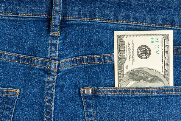 billete de cien dólares en el bolsillo trasero de vaqueros azules. billetes de dólar en bolsillo vaquero - Foto, Imagen