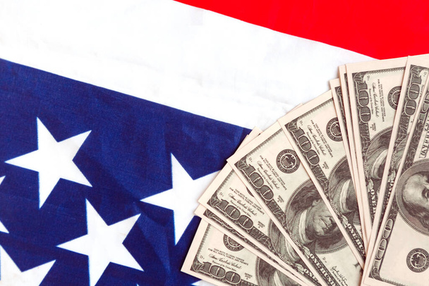 Banconote in dollari sulla bandiera nazionale americana. Copia lo spazio per il testo - Foto, immagini