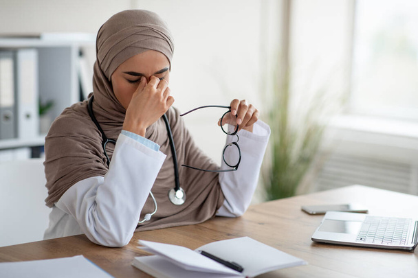 Médico feminino tendo problema de visão enquanto trabalhava com laptop - Foto, Imagem