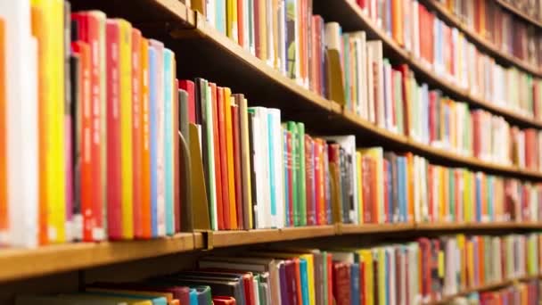 Camera beweegt langs gebogen planken met boeken in de bibliotheek - Video