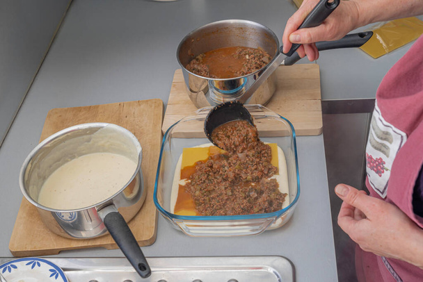París, Francia - 02 14 2021: Preparación de lasaña con carne, espinacas, tomates y bechamel - Foto, Imagen