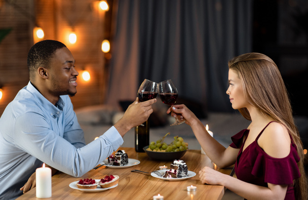 heureux noir homme et blanc femme ayant romantique dîner dans restaurant - Photo, image