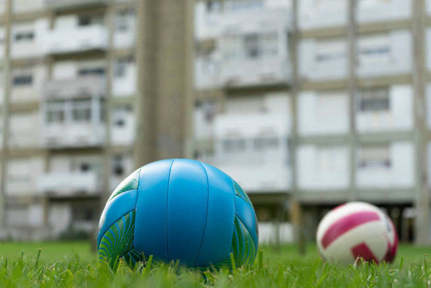 Volejbalové míče na trávě s budovou v pozadí - Fotografie, Obrázek