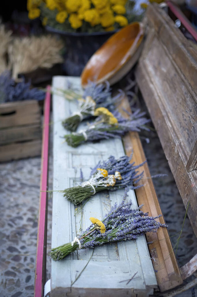 bukiety kwiatów lawendy na zabytkowej drewnianej ławce na targu ulicznym, festiwal lawendy Brihuega, Guadalajara, Hiszpania, wybiórcze skupienie - Zdjęcie, obraz