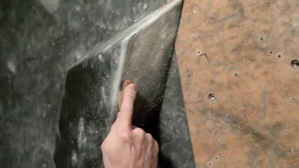 CHIUSURA: Uomo irriconoscibile spazzola via il magnesio da una presa da arrampicata in palestra interna - Filmati, video
