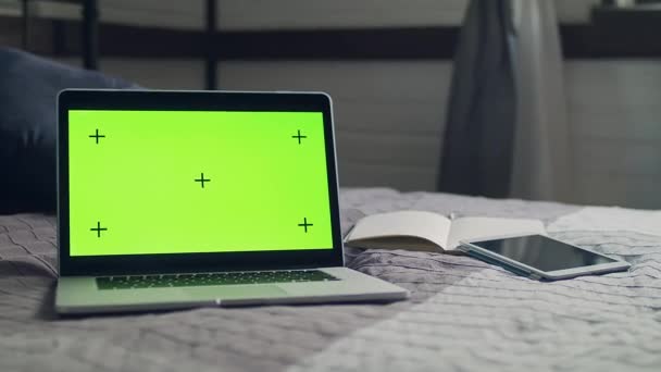Zöld képernyő nyomjelzőkkel. A laptop az ágytakarón fekszik.. - Felvétel, videó