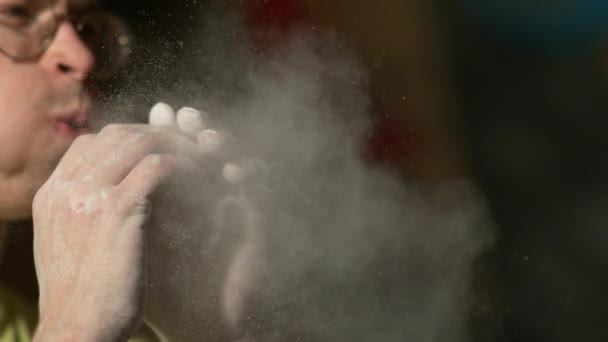 CERRAR: Hombre escalando en el interior sopla en sus palmas y elimina el polvo de magnesio - Metraje, vídeo