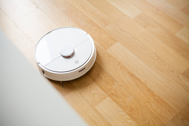 Staubsaugerroboter führen zu einer bestimmten Zeit die automatische Reinigung der Wohnung durch. Smart Home. - Foto, Bild