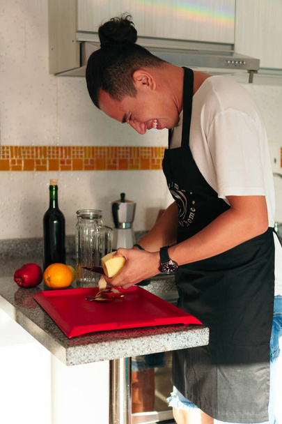 Man snijdt appels om sangria te maken voor thuis, thuis koken interieur. Zelfgemaakt eten en drinken - Foto, afbeelding