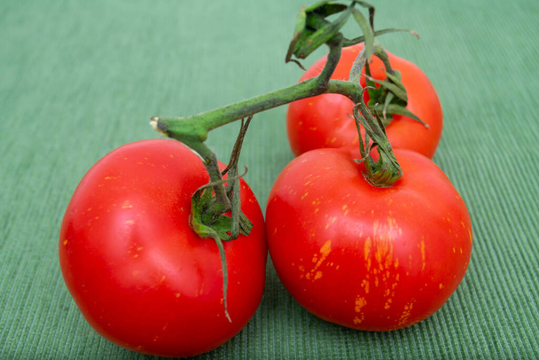 Rote Tomaten mit grünen Zweigen für Salat. - Foto, Bild