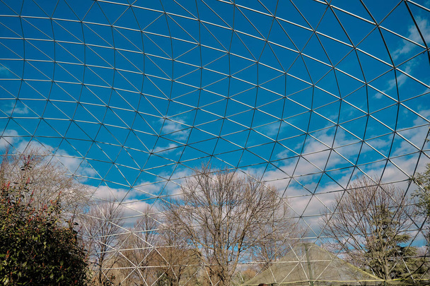 a nagy ketrecben az állatkertben. szárított fák és növények csodálatos kék ég és fehér felhő háttér együtt fehér konstrukció készült fehér pálcikák kupola. - Fotó, kép