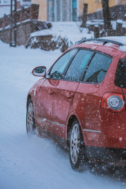 Kış boyunca kırmızı arabanın ivmesi yokuş yukarı. - Fotoğraf, Görsel