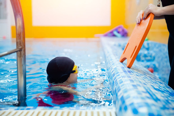Pływanie trener kobieta instruowanie dziecko dziewczyna w basenie, koncepcja pływak dzieci - Zdjęcie, obraz