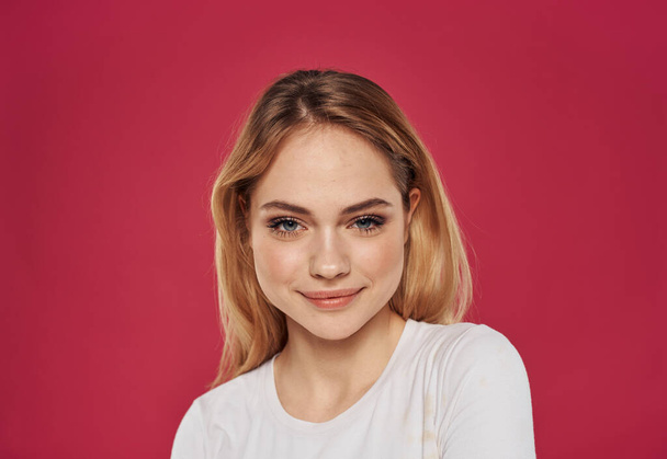 Femme romantique sur fond rouge dans un t-shirt blanc Maquillage sur le visage sourire - Photo, image