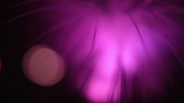 Obrotowa lampa z włókna szklanego oświetlona różnymi kolorami i efektem bokeh - Materiał filmowy, wideo
