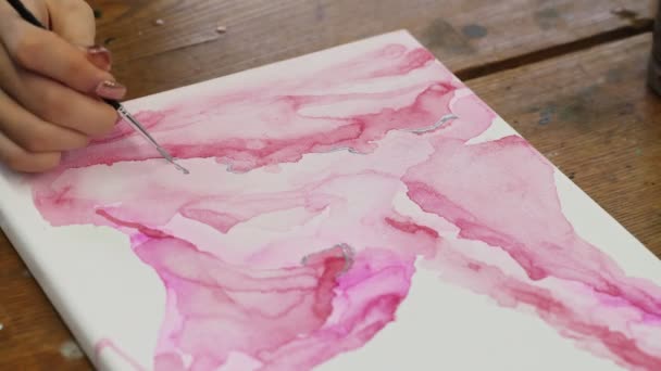 Vloeibare kunst. Abstract roze schilderij. Close up van vrouwelijke kunstenaar gebruikt penseel en zilveren verf om een abstract beeld te schetsen - Video