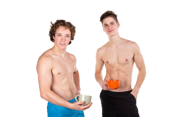 Two attractive young guys are drinking hot coffee. White background. - Φωτογραφία, εικόνα