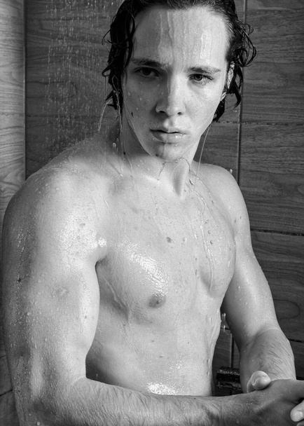 Young attractive guy washes in the shower. - Фото, зображення