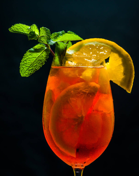 Cocktail in un bicchiere di colesterolo con agrumi e liquore allo champagne, in un ambiente buio - Foto, immagini