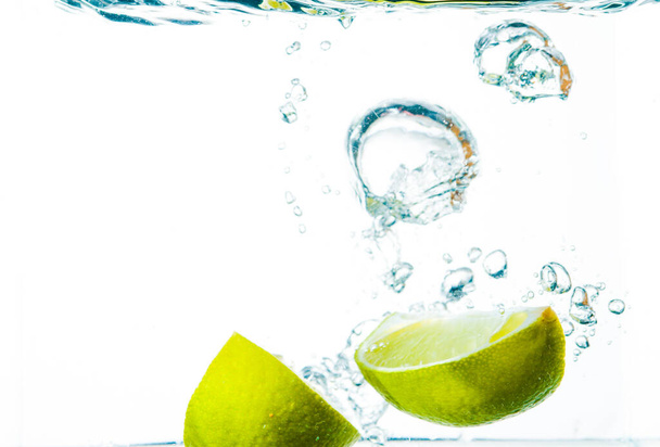 Limão em água com respingo verde brilhante fresco - Foto, Imagem