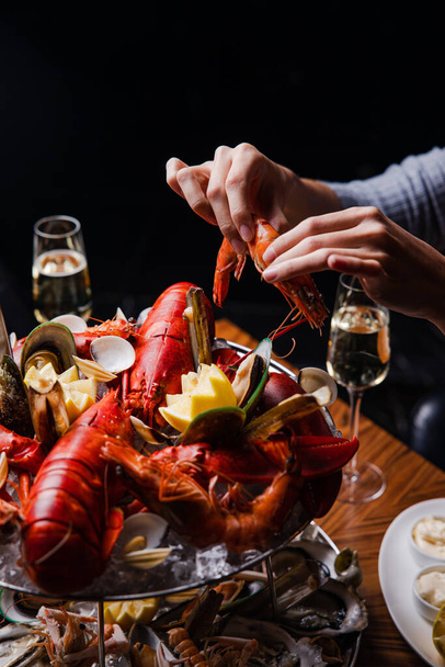 view of a woman eating lobster with her hands - Photo, Image