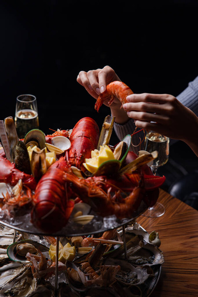 view of a woman eating lobster with her hands - Photo, Image