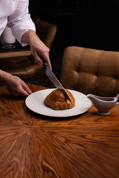 closeup view of man cutting delicious meatloaf with a knife - Fotó, kép