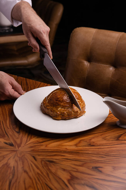 vue rapprochée de l'homme couper délicieux pain de viande avec un couteau - Photo, image