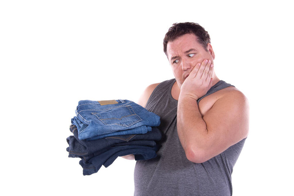 Vicces kövér fickó diétázik. Boldog ember és a ruhák választéka. Fehér háttér. - Fotó, kép